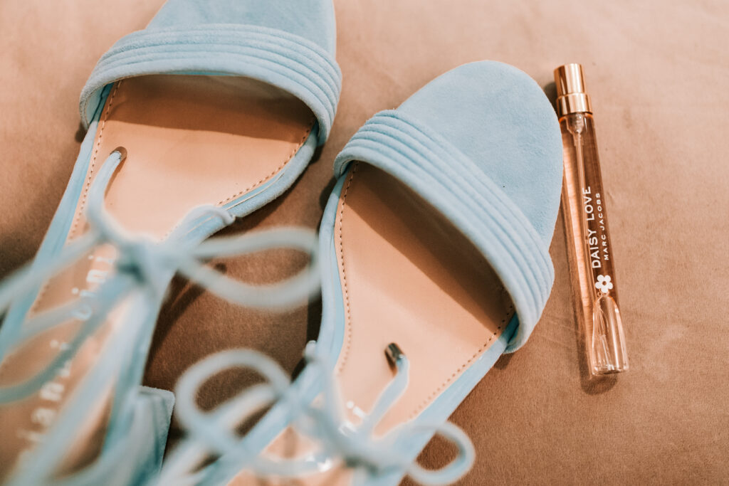 Pastel blue strappy shoes and Daisy Love perfume by Marc Jacobs as part of the getting ready details for a bride. 