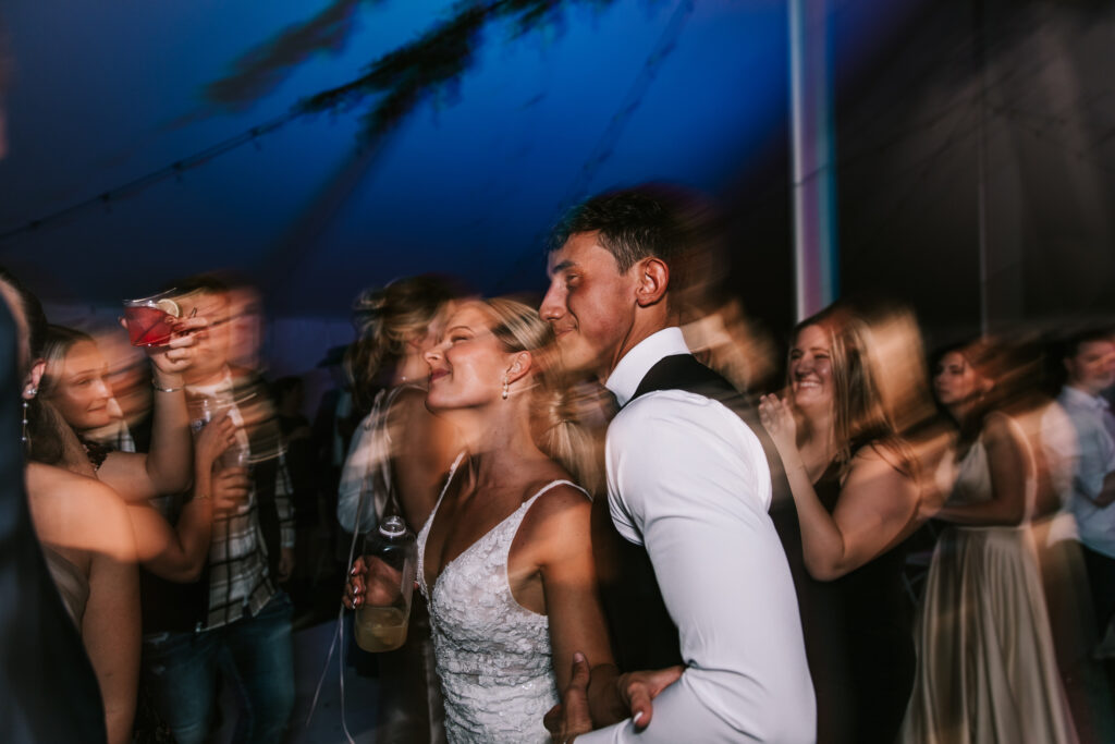 A bride and groom dance at their wedding reception. The motion makes the picture fit the blurry wedding photo trend.