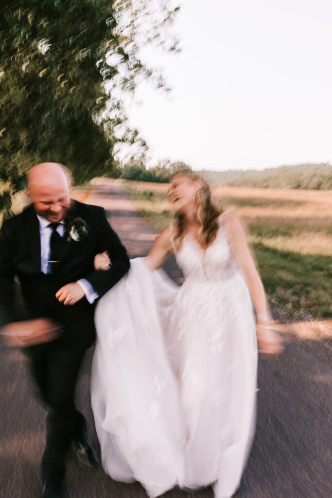 Bride and groom walk down the lane of their wedding venue. Picture taken in the blurry wedding photo trend. 