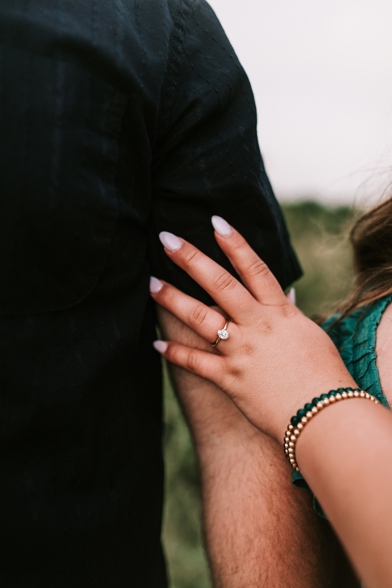 engagement photo featuring her hand resting on his arm