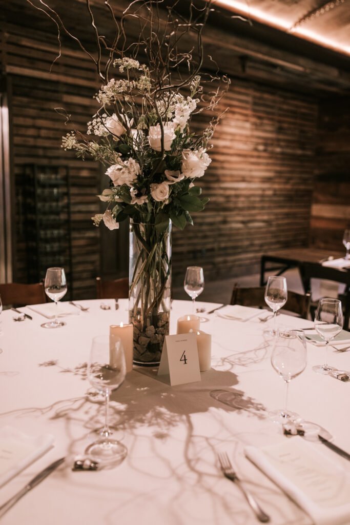 Tall floral arrangment on table setting at Finley Farms for a black tie wedding.