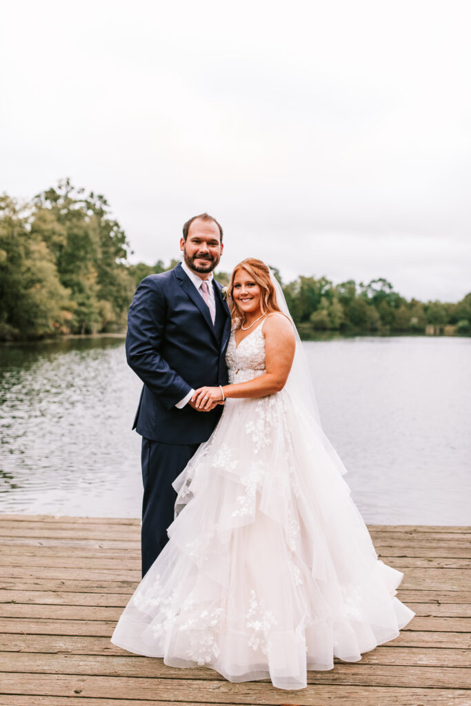 Bride and groom on the dock in front of lake  in Lebanon Missouri. Wedding photography by Bailey Morris.
