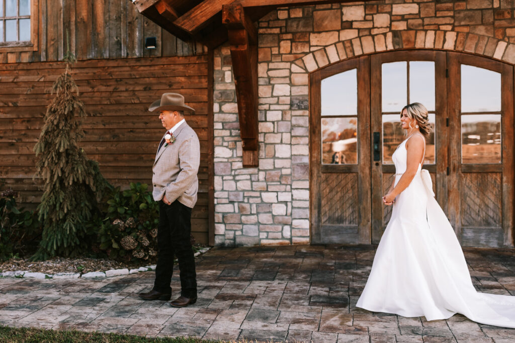 Bride having a first look with her Dad in front of the stone arch at Mighty Oak Lodge in Lebanon, Missouri. 