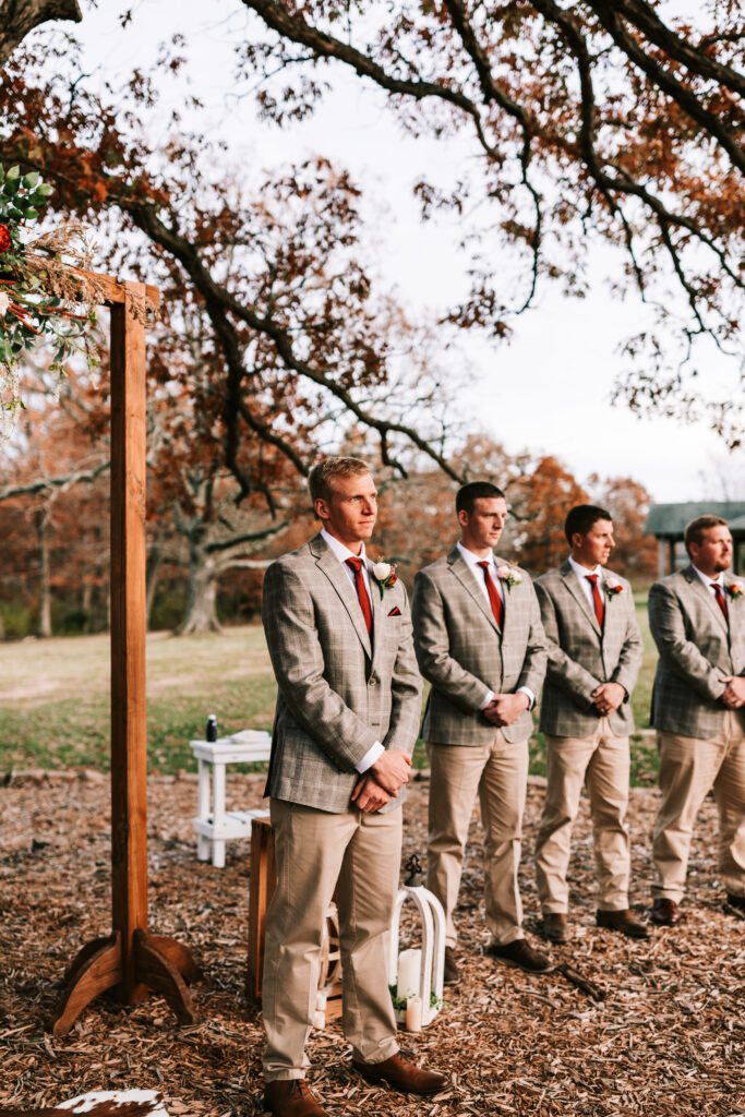 Groom and his groomsmen waiting under the oak tree for the bride to walk down the aisle at their outdoor ceremony. 