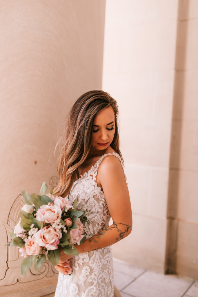 Kansas City bride holding her spring season wedding bridal bouquet with pink flowers and greenery photographed by Bailey Morris photography.
