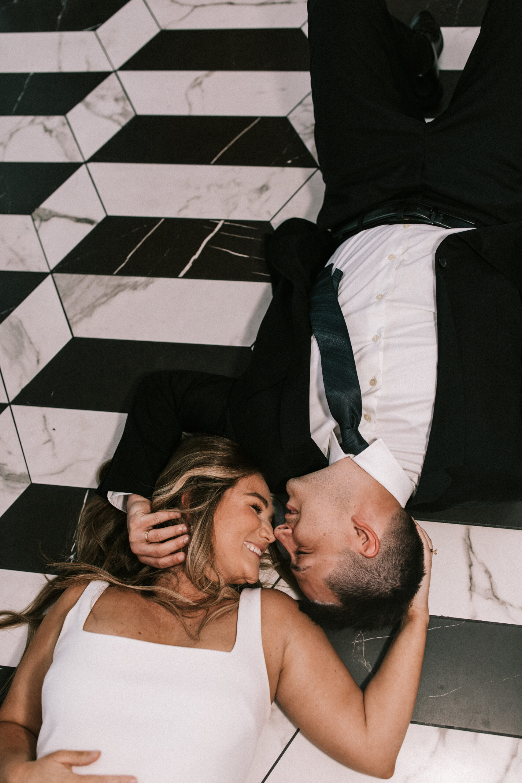 Bride and groom cradling each other's heads with the tile floor as the backdrop at a Hotel Vandivort wedding. 