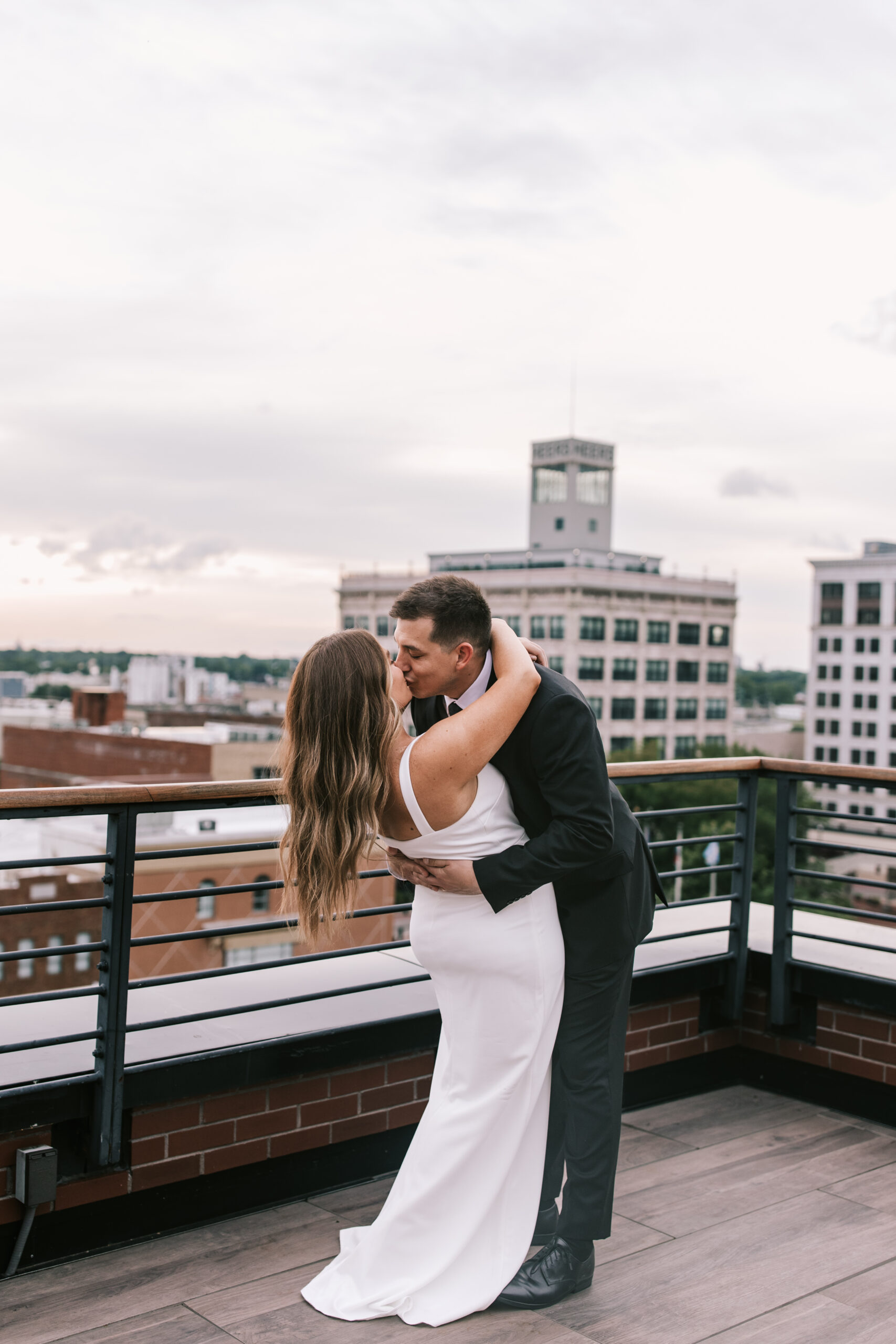 bride and groom kissing at the end of the ceremony at their rooftop wedding in Downtown Springfield, Missouri at Hotel Vandivort