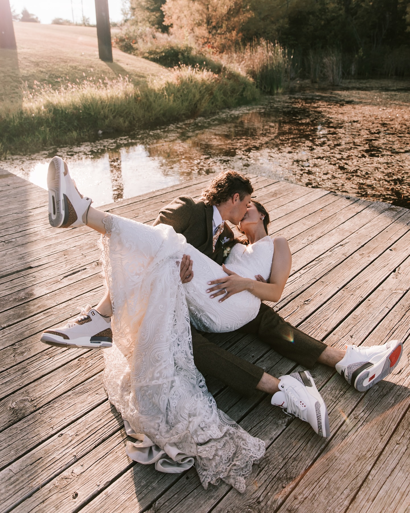 Newly married couple kissing on the dock at Mighty Oak Lodge. 