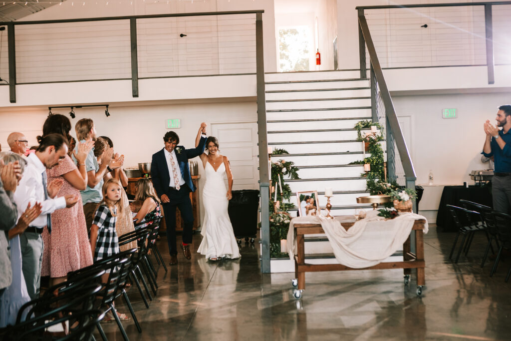 Bride and groom entering their wedding reception at The Atrium wedding venue in Branson, Missouri.
