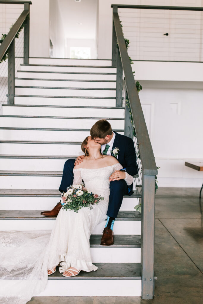 Bride and groom kissing on the stairwell of The Atrium Wedding Venue in Branson, Missouri.
