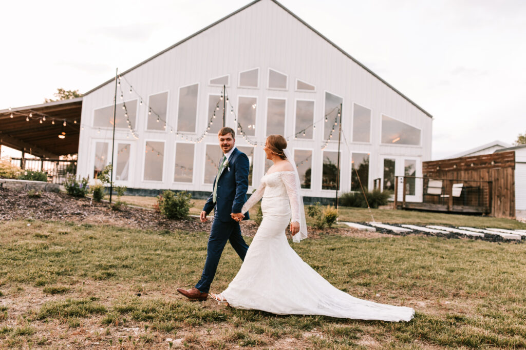 Bride and groom walking in front of The Atrium Wedding Venue in Branson, Missouri photographed by Bailey Morris Photography.