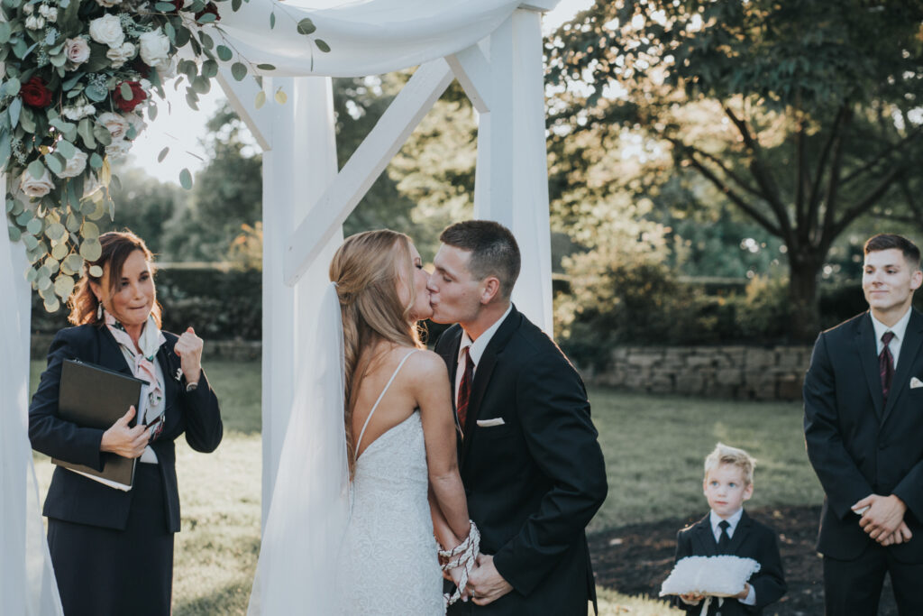 Groom kissing bride on the terrace at Haseltine Estate wedding venue in Springfield Missouri. Photo by Morris Wedding Photography.
