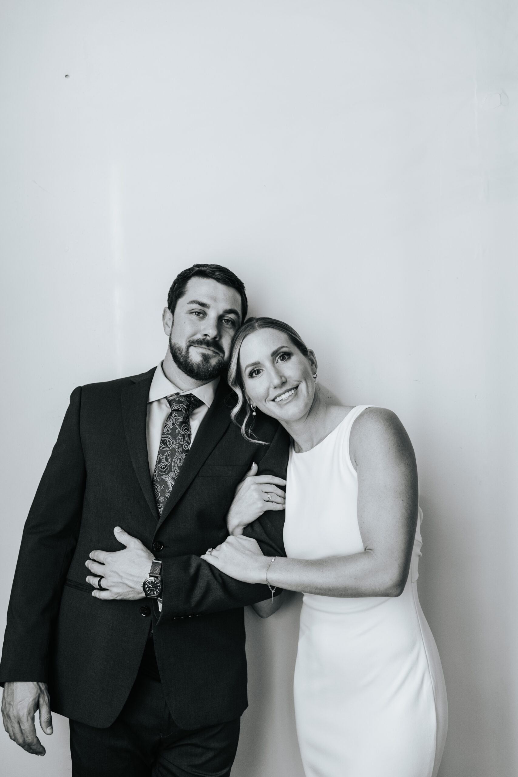 Groom and bride link arms in a Black and white wedding portrait 