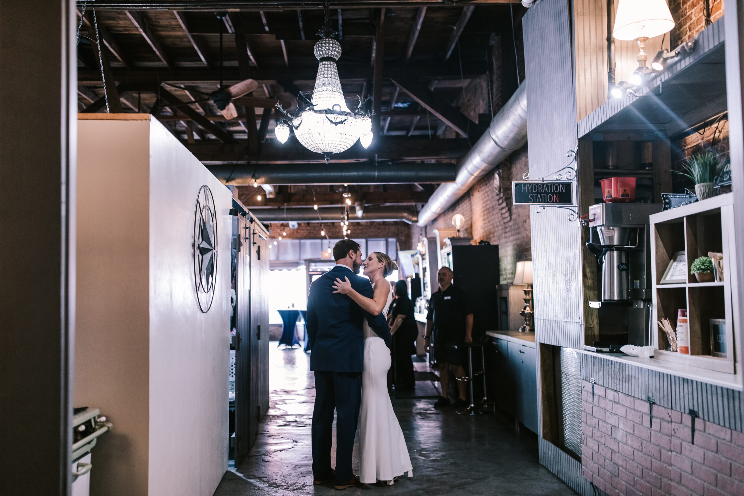 Couple embraces in the hallways of Venue on Brick reception space in Ozark Missouri.