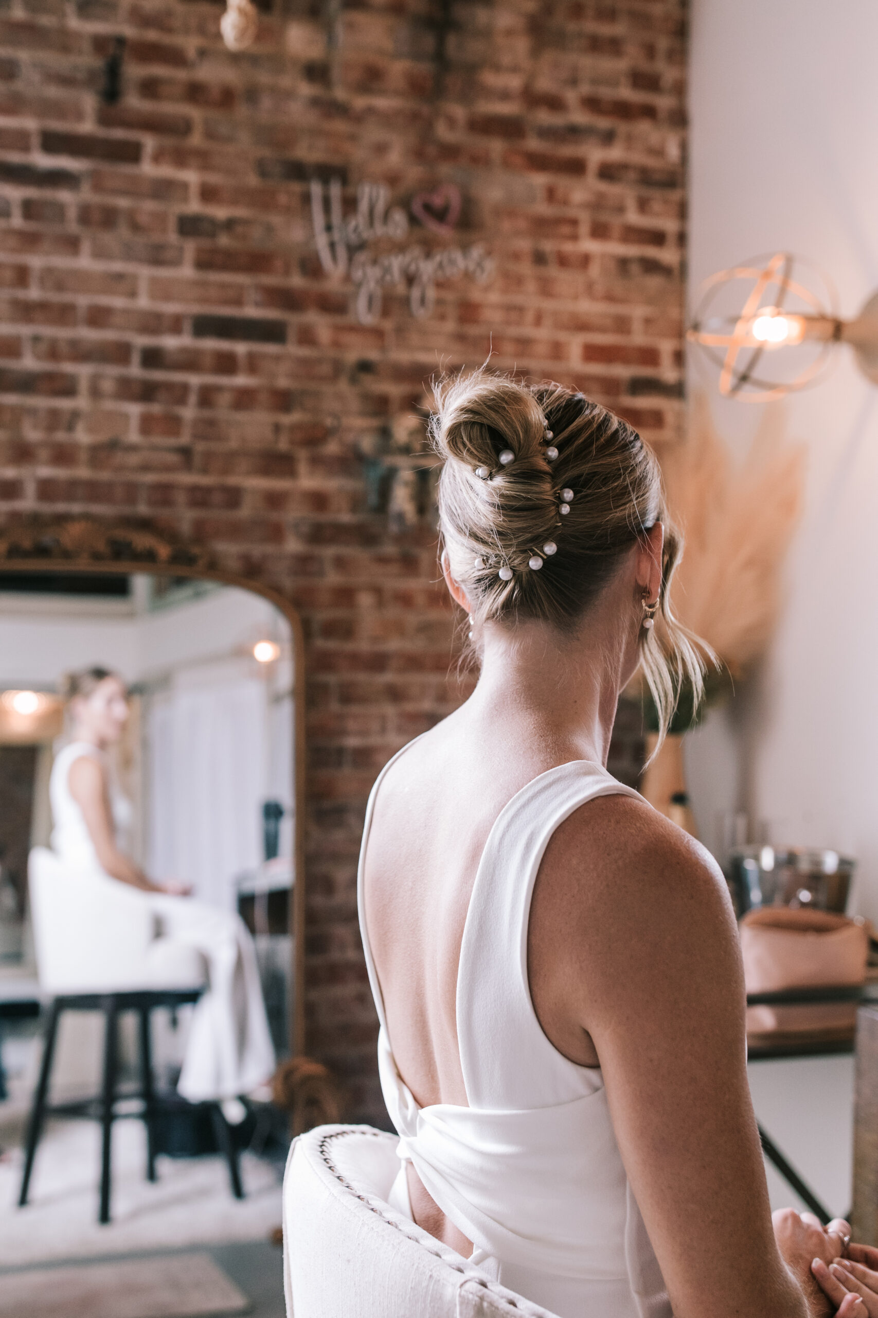 Bride glances in mirror in the bridal suite of Venue on Brick.