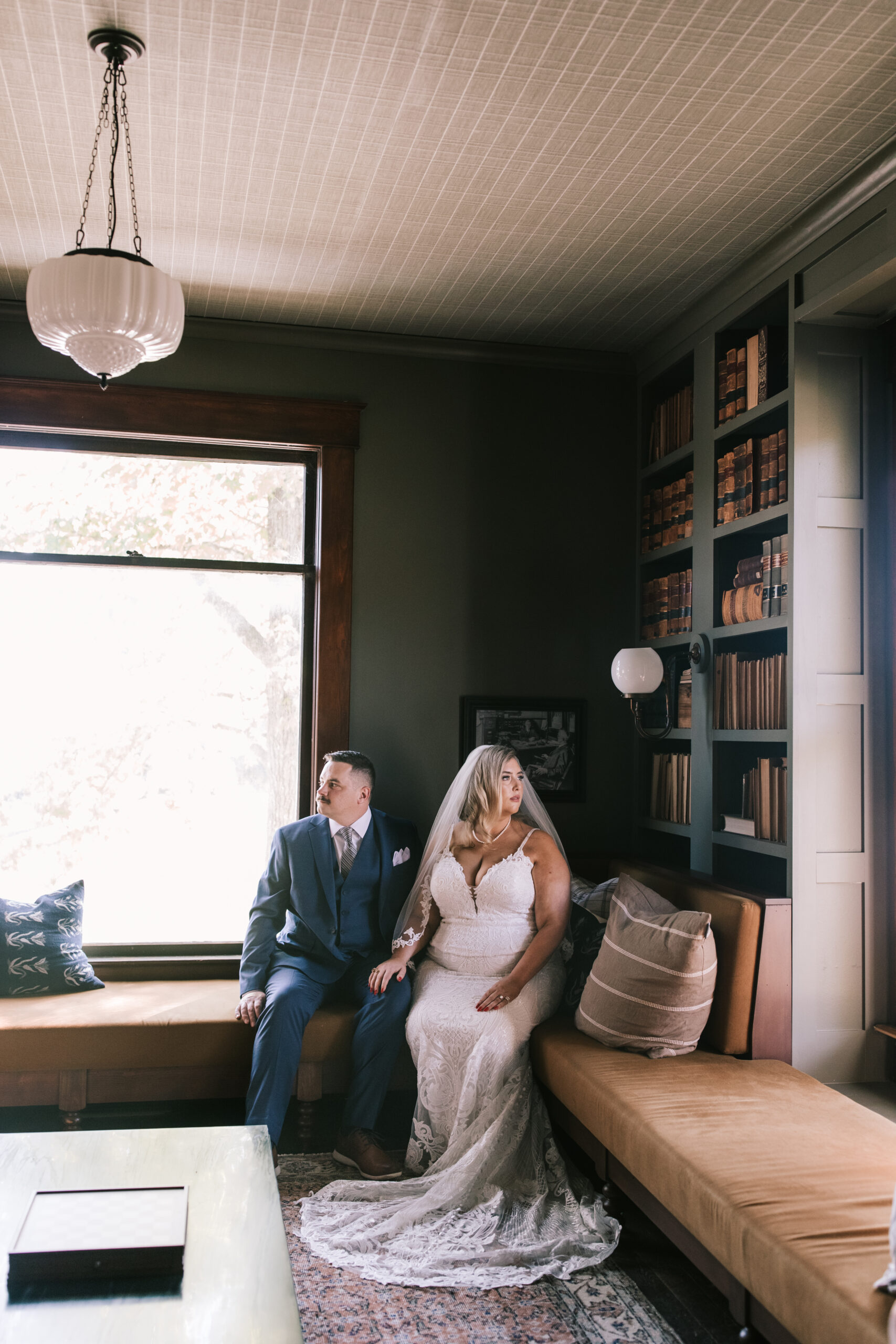 Groom and bride sitting in the library of the Marley House at their Finley Farms wedding.