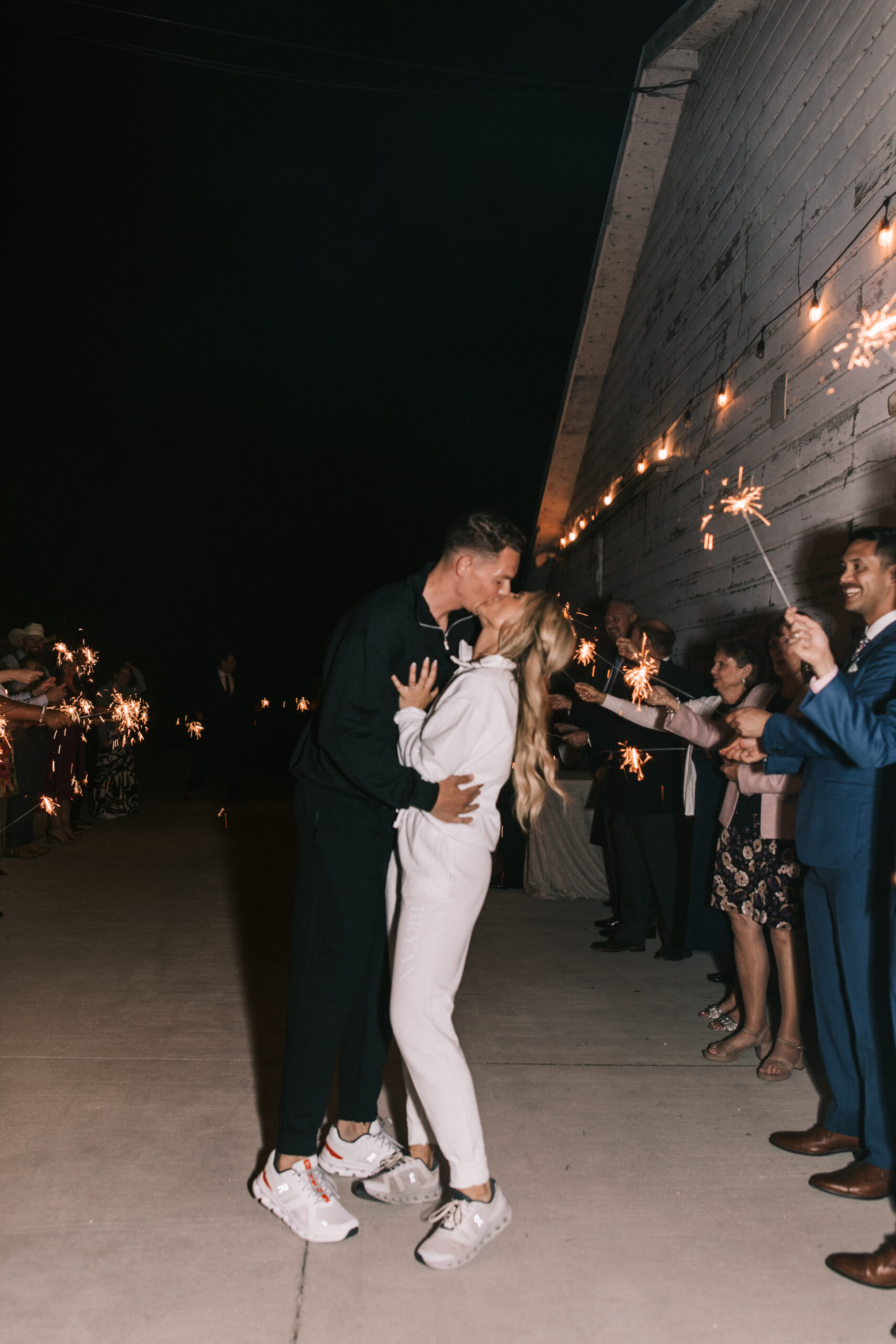 Bride and groom kiss before their sparkler exit.